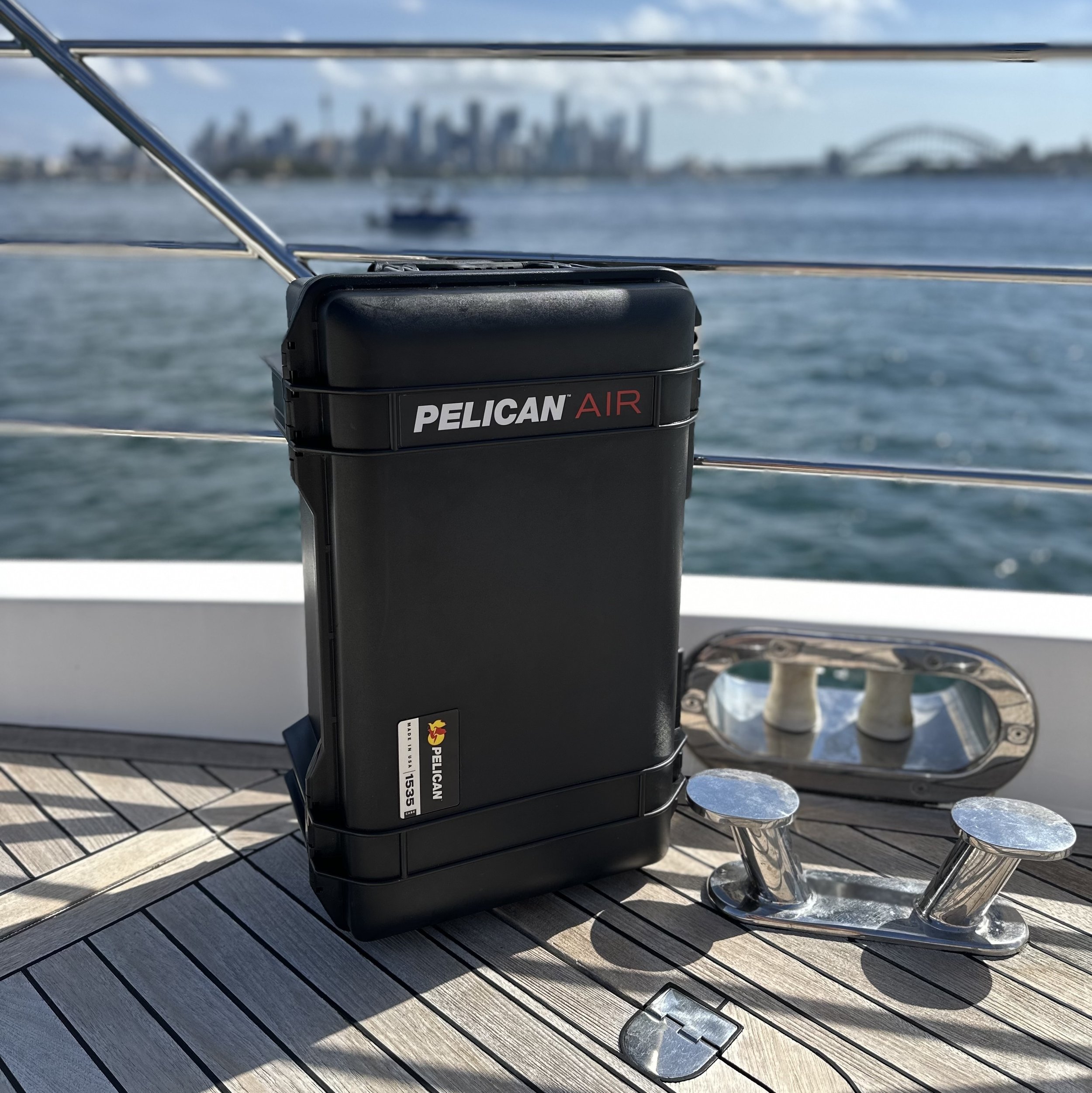 Pelican Air case on the deck of a boat, city skyline across the water